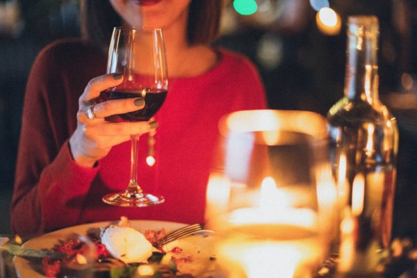 A woman enjoying wine after a fine meal in a fancy restaurant